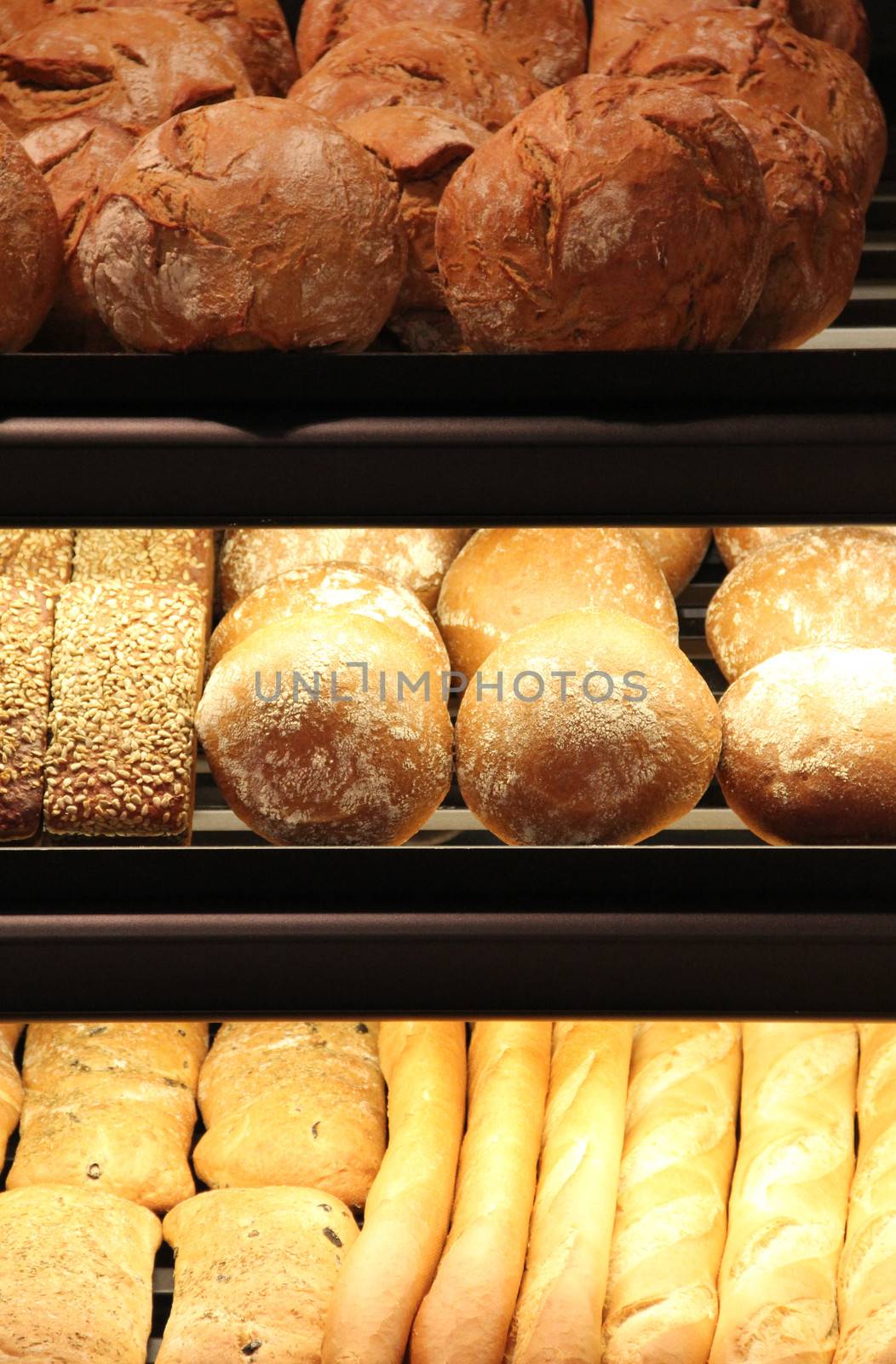 different appetizing bread on showcase in supermarket
