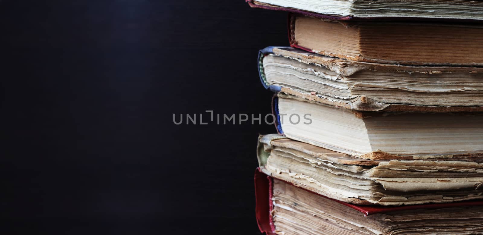 Corner of old books stack on dark background