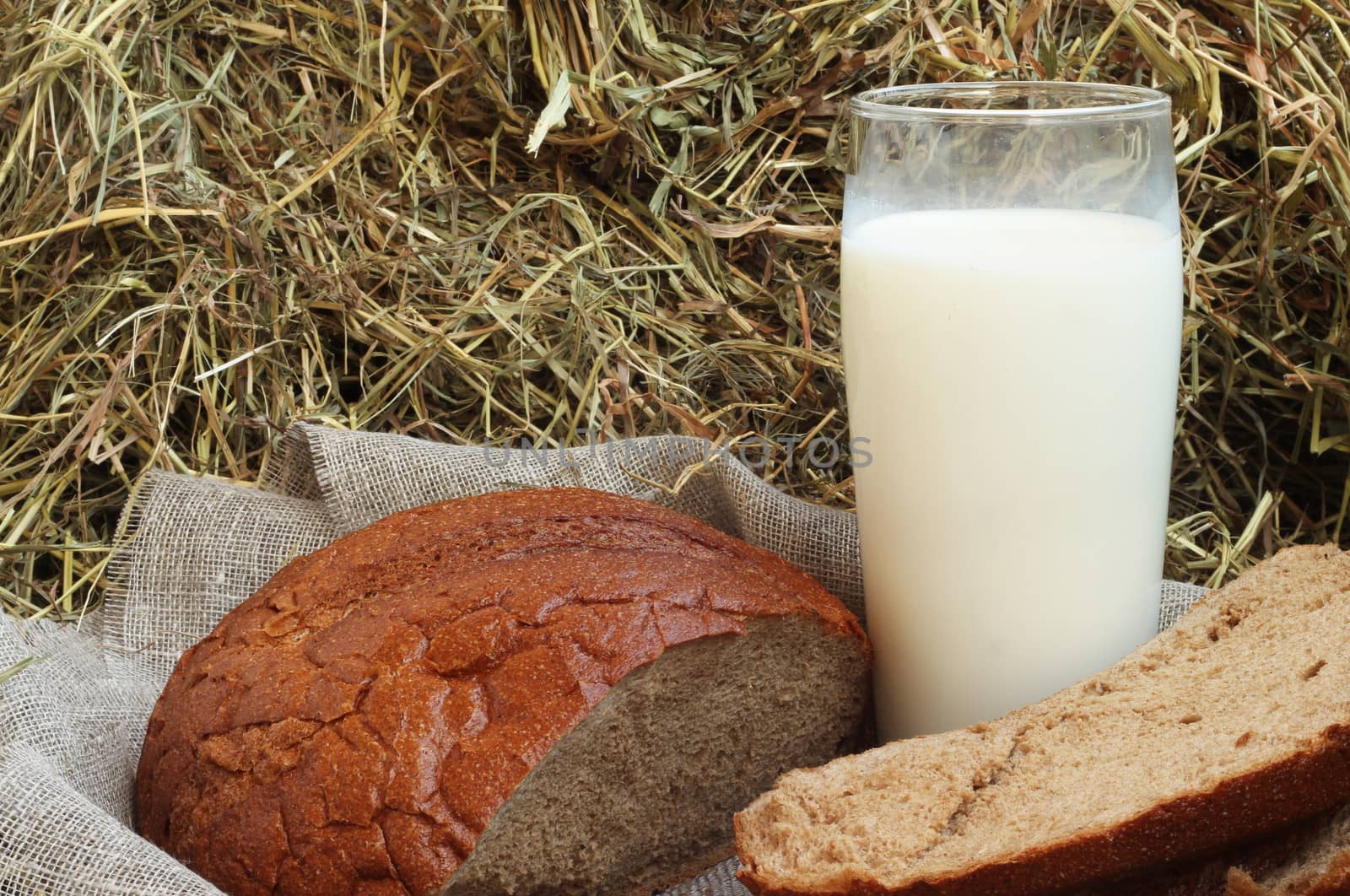 Brown fresh sliced bread and milk on hay