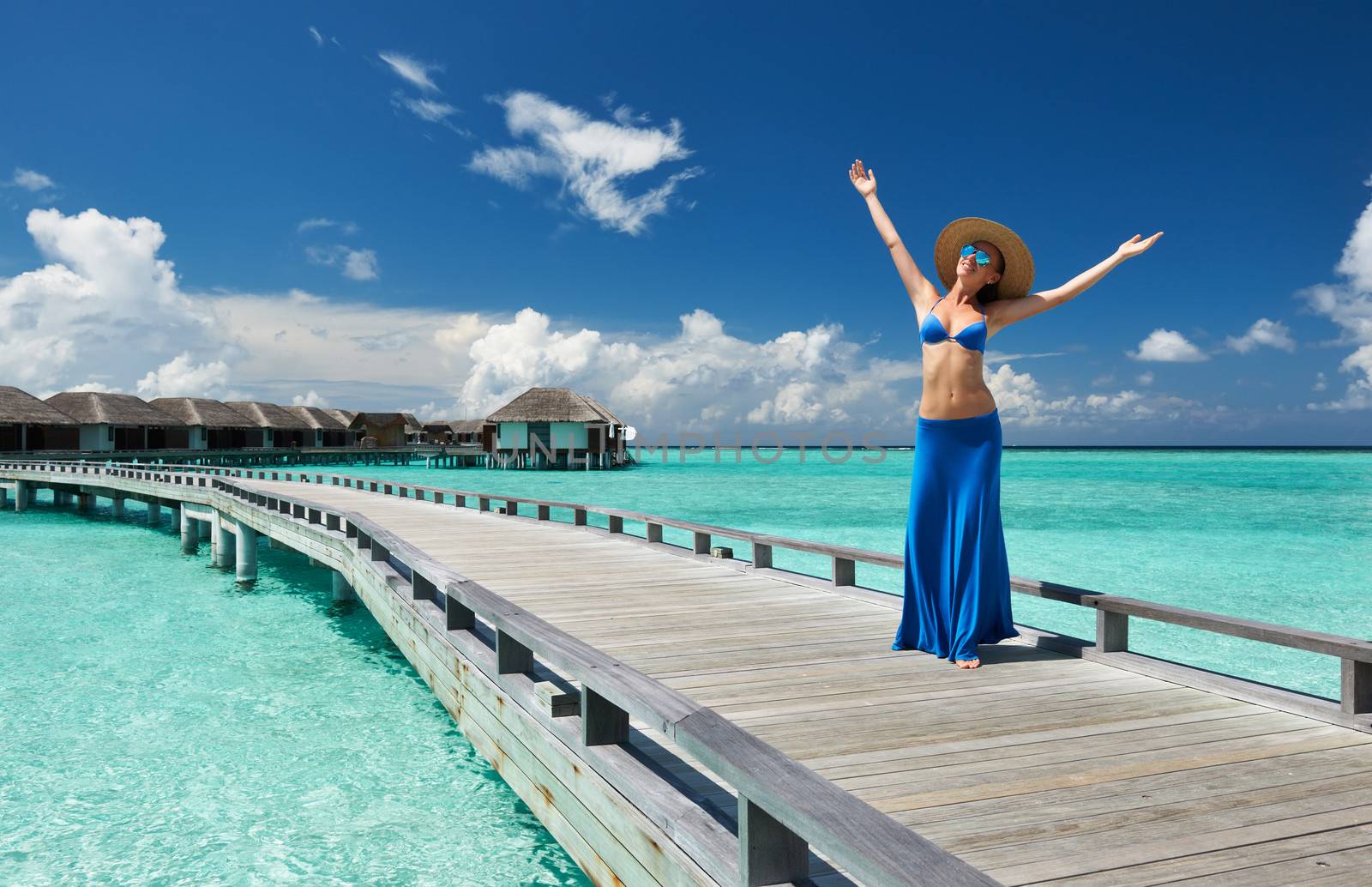 Woman on a tropical beach jetty at Maldives