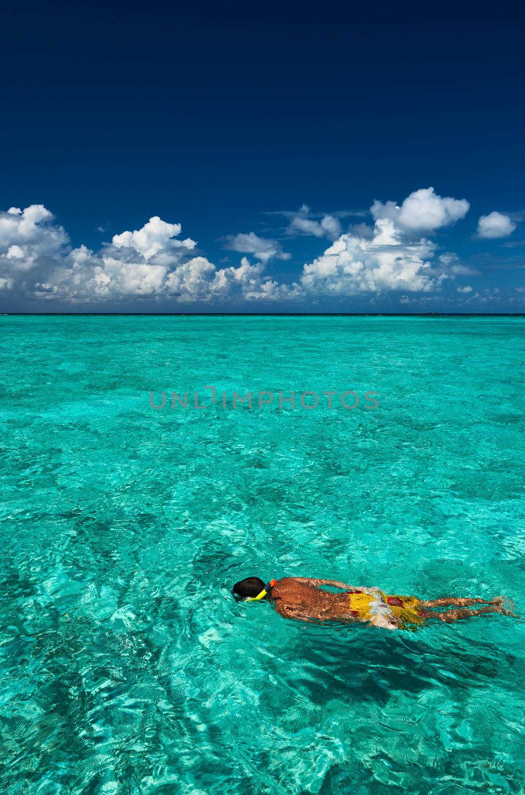 Man snorkeling in crystal clear turquoise water at tropical beach