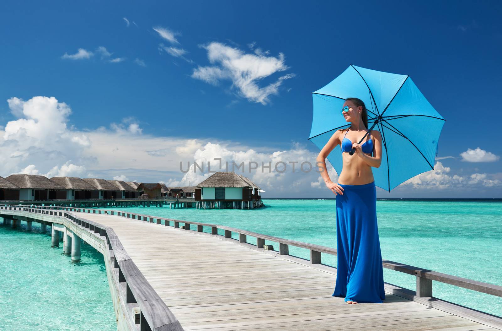 Woman on a tropical beach jetty at Maldives