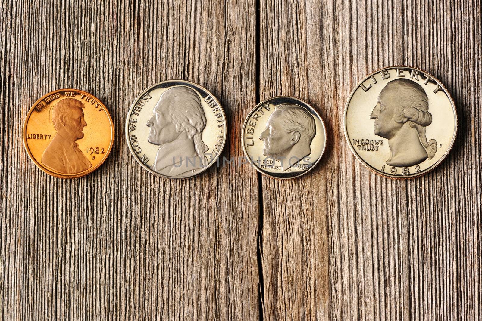 Four US cent coins over wooden background