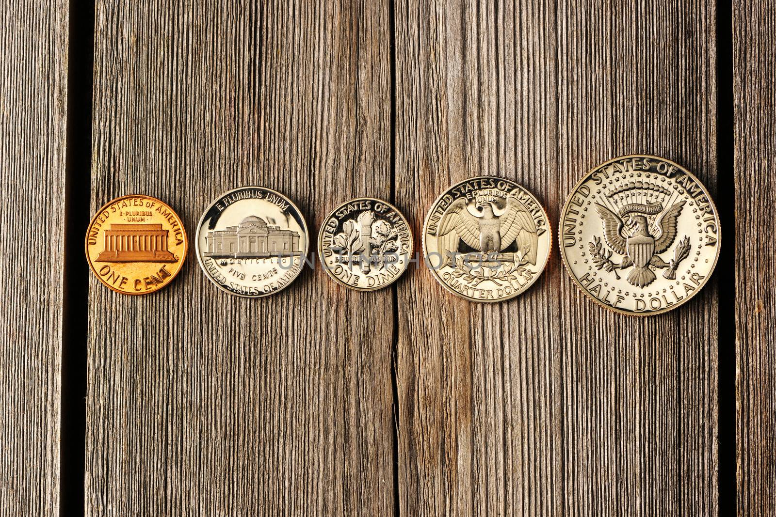 Five US cent coins over wooden background