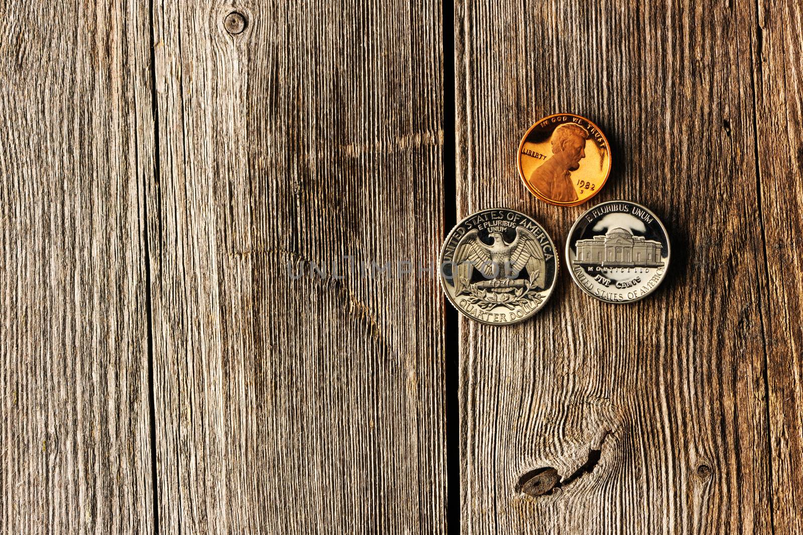 Three US cent coins over wooden background