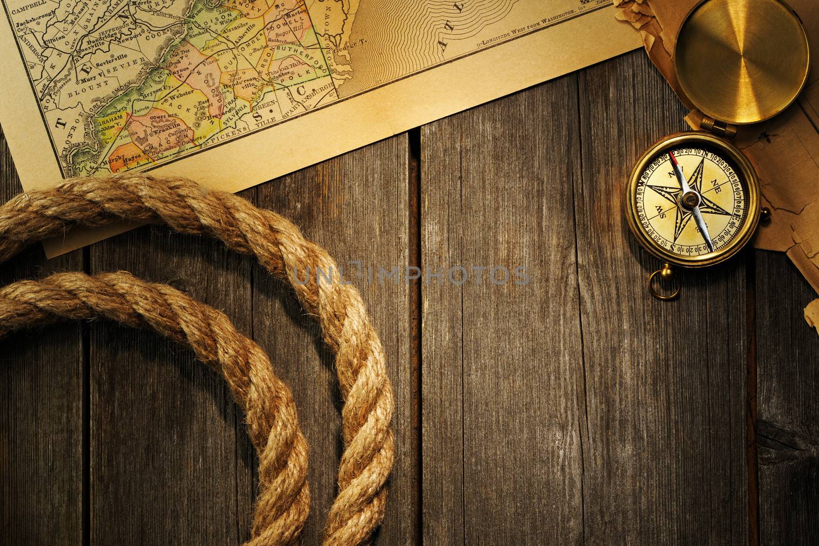 Antique brass compass and rope over old map