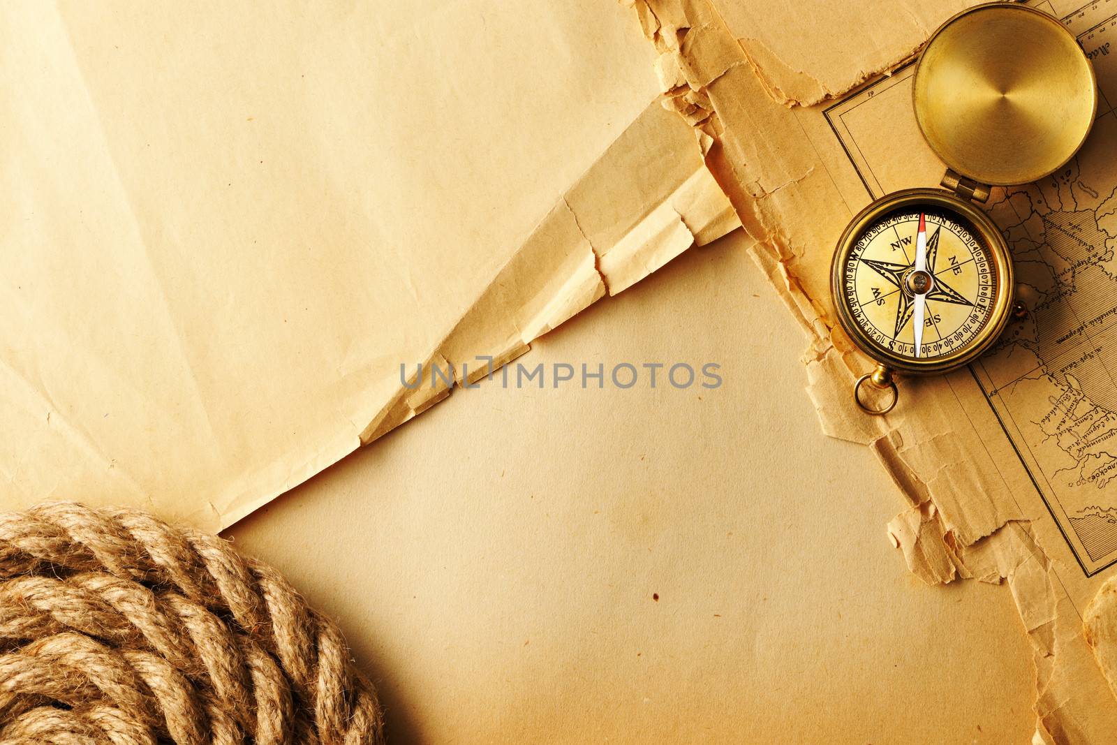 Antique brass compass and rope over old map