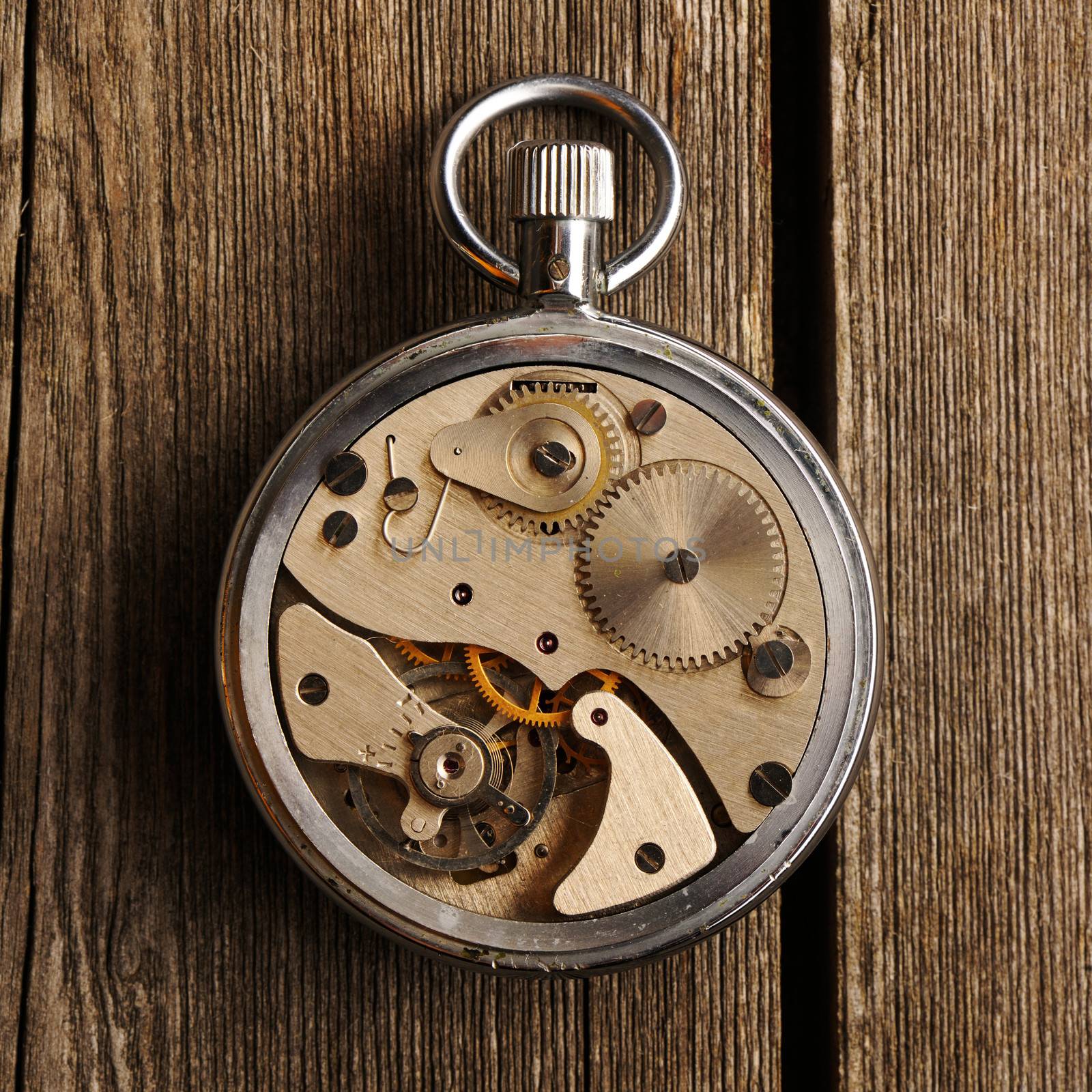 Clockwork mechanism over wooden background 