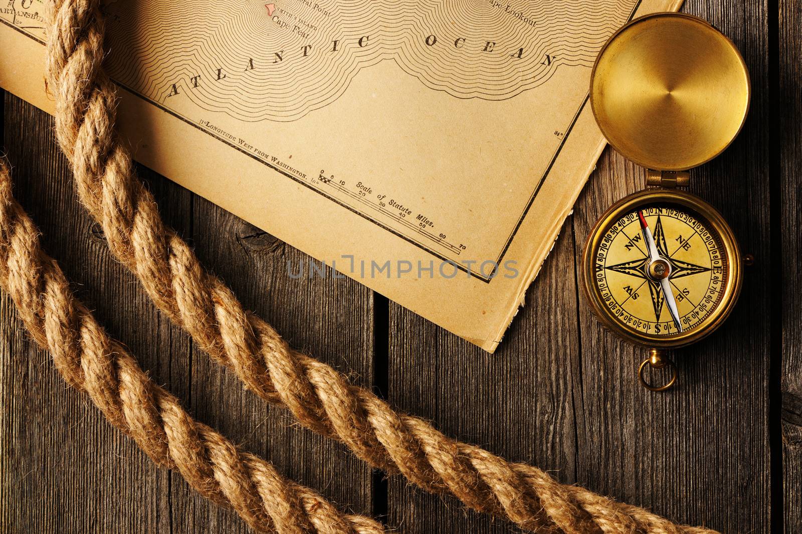 Antique brass compass and rope over old map