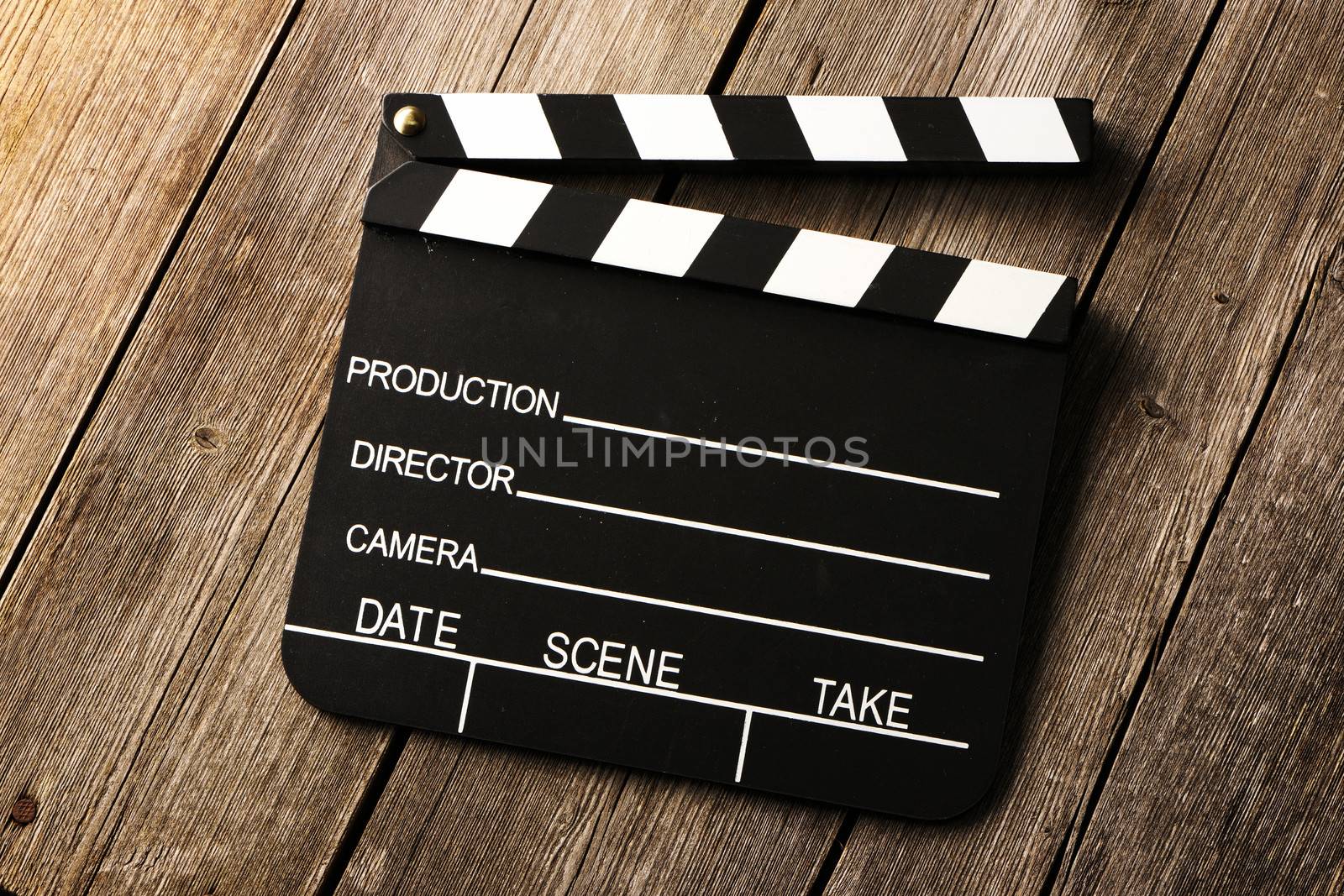 Movie production clapper board over wooden background
