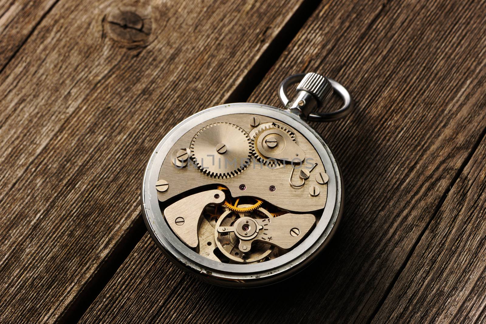 Clockwork mechanism over wooden background 
