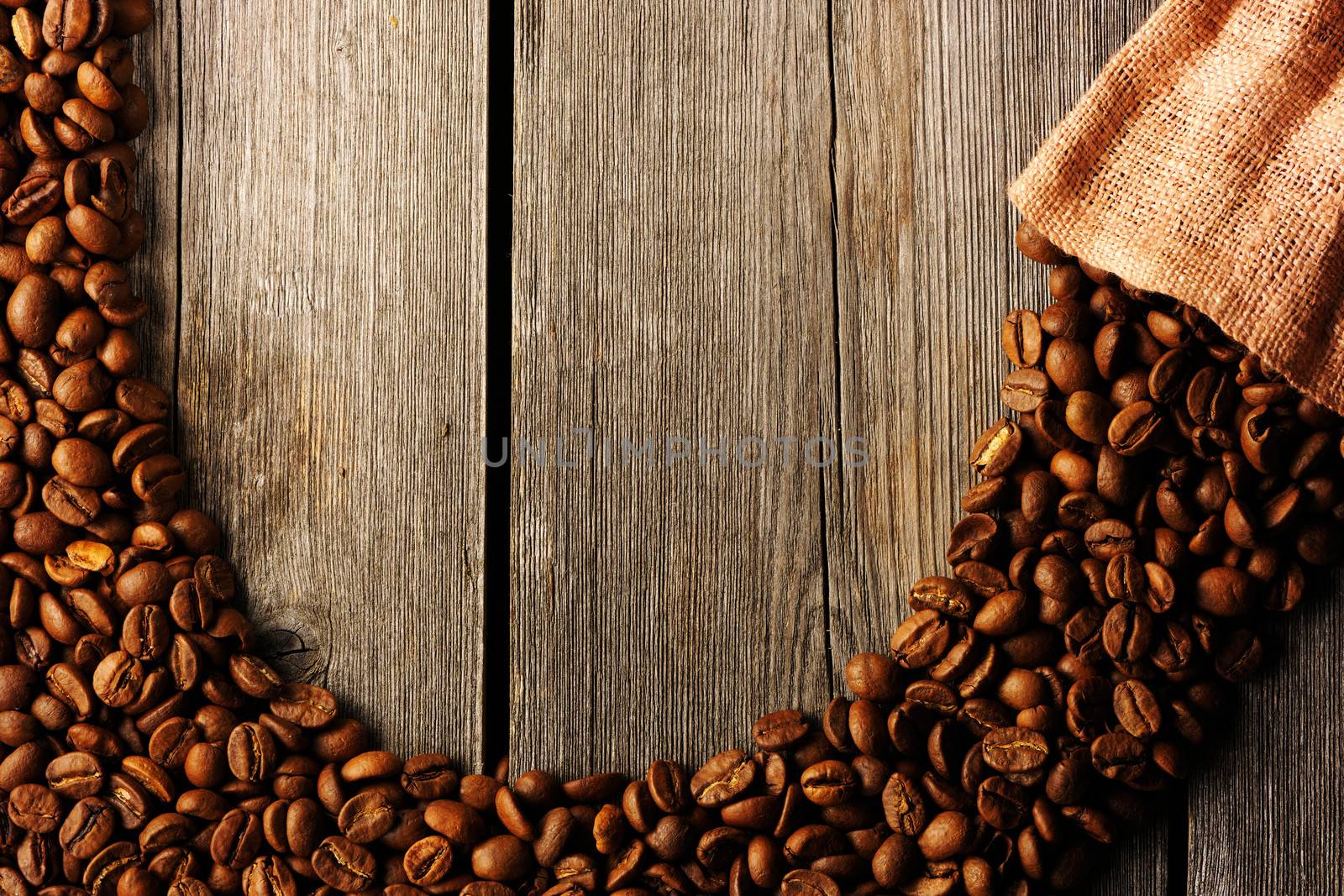 Coffee beans and bag over wooden background