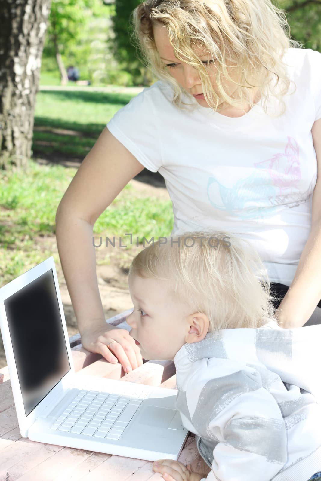 mother and child with laptop by destillat