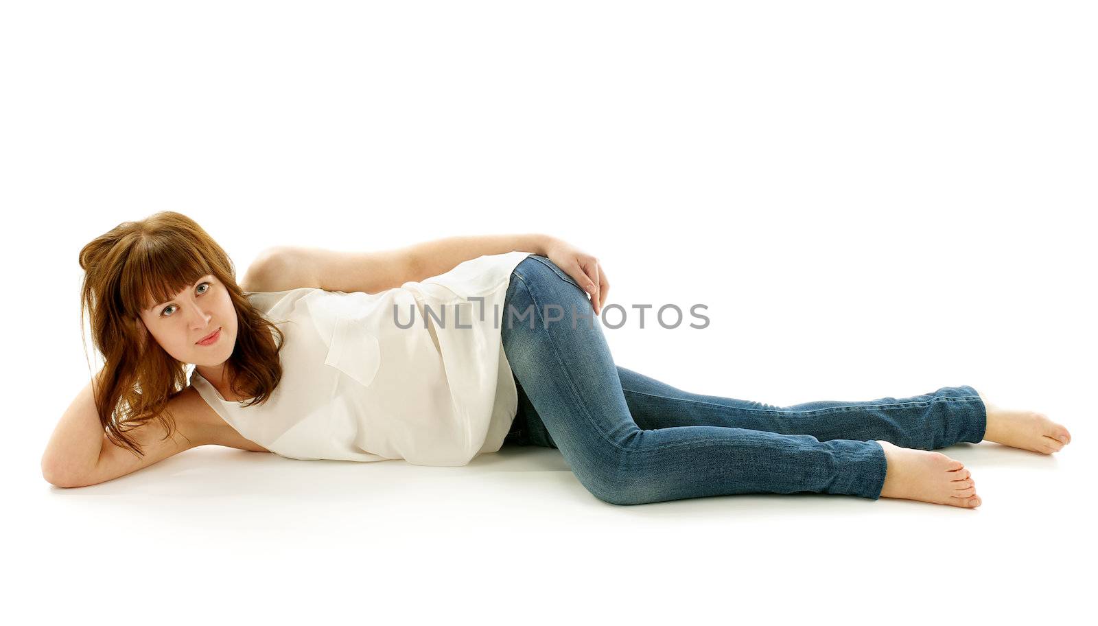 Ginger Hair Young Attractive Woman Lying Down on Floor in Jeans and Barefoot on white background