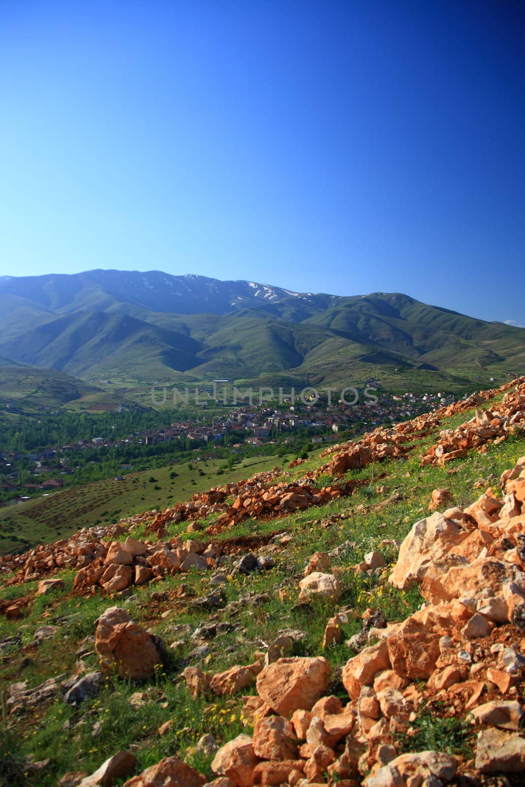 village between hills on spring day with blue sky