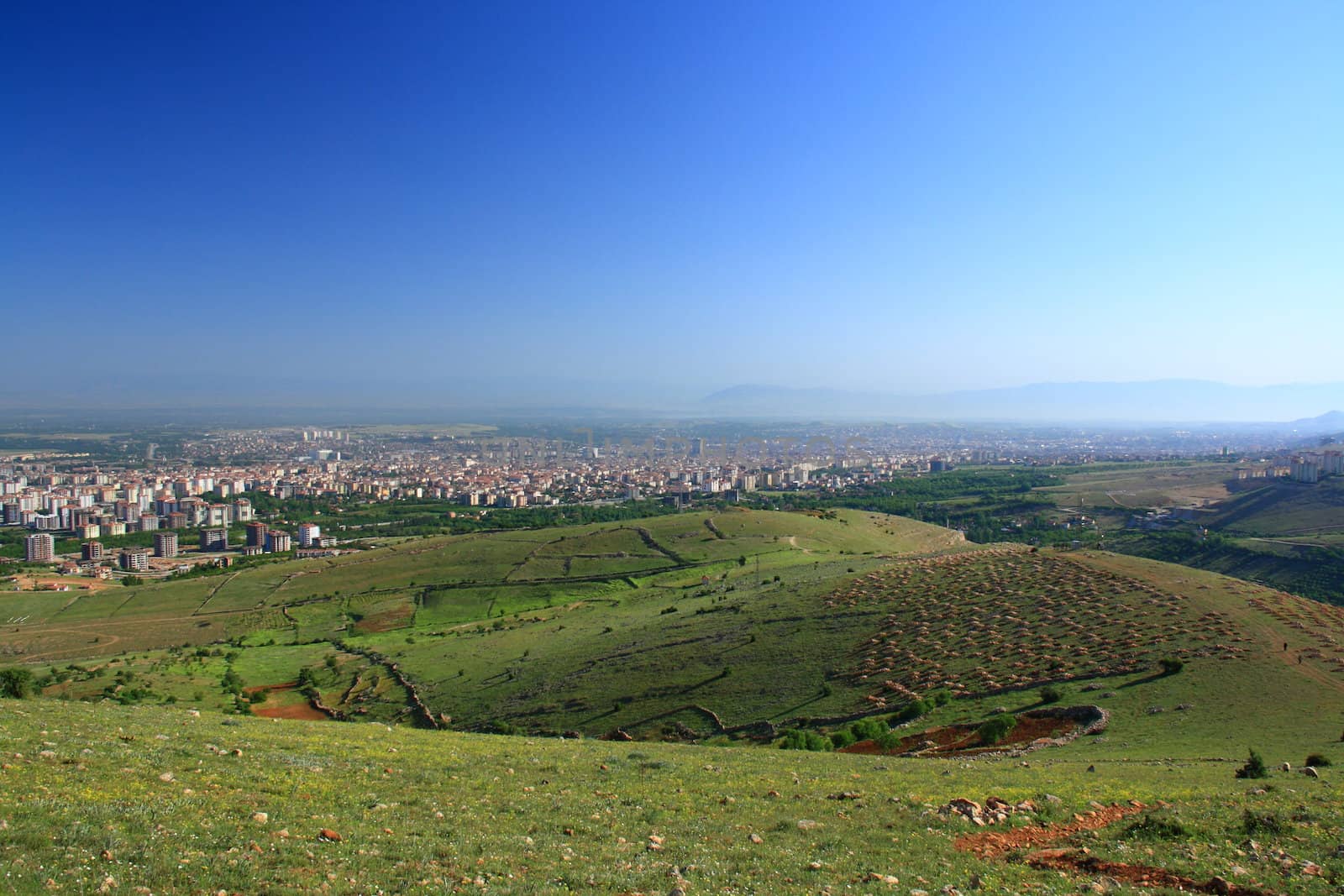 village between hills on spring day with blue sky