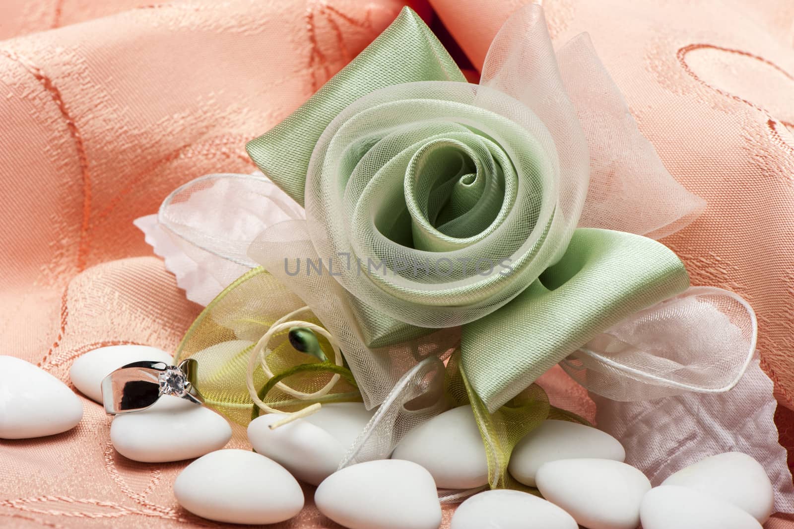 wedding favors and wedding ring on on colored background