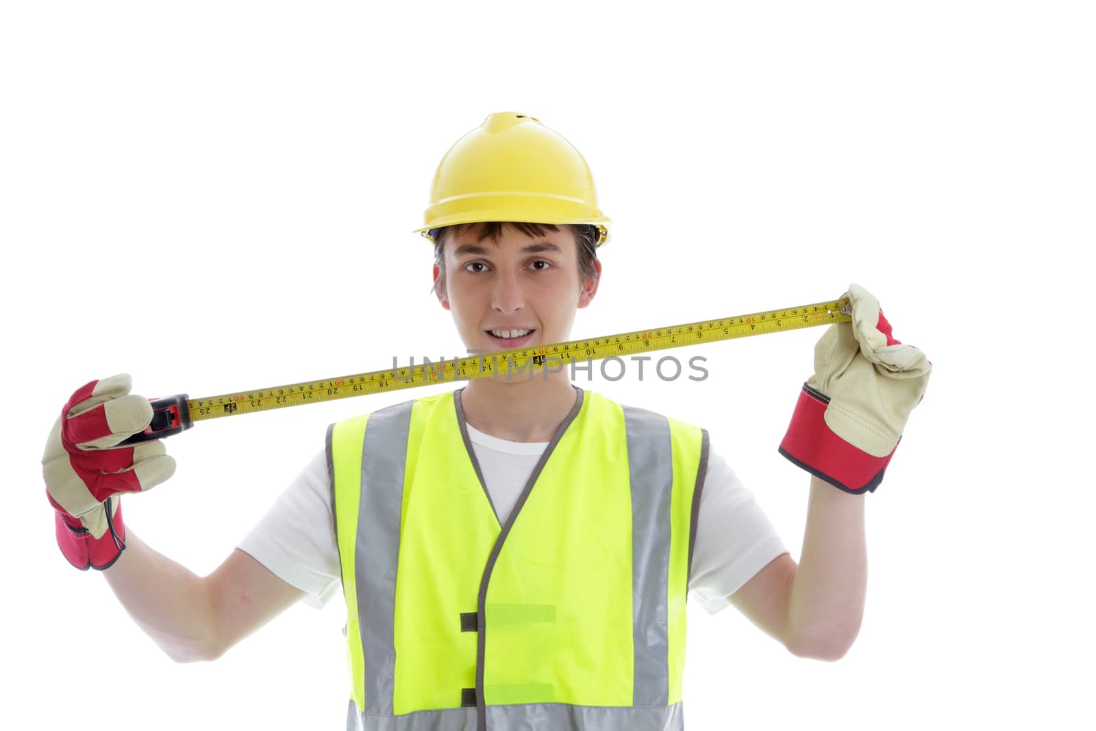 Young apprentice holding a builders tape measure and smiling