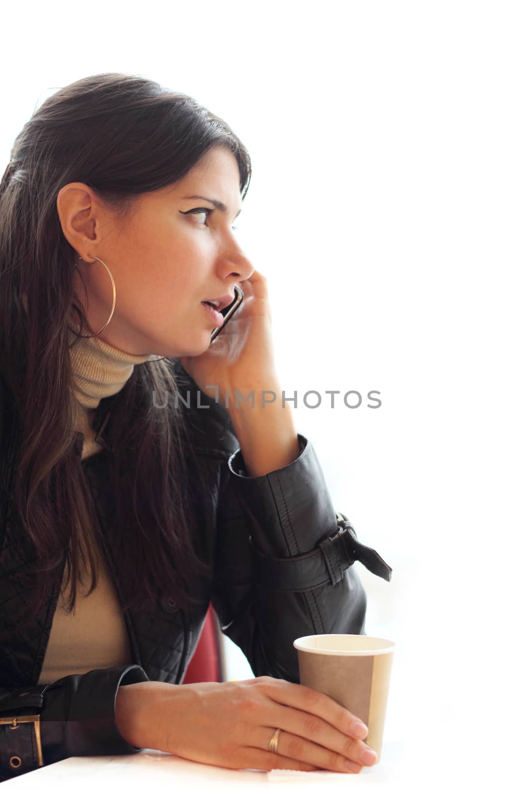 Woman with coffee  talking on cellphone by destillat