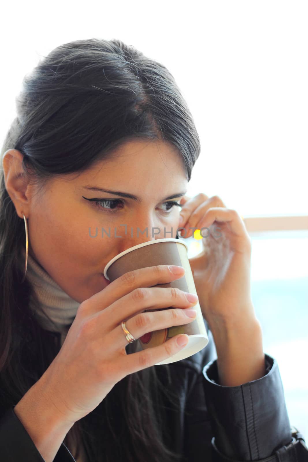 Beautiful young woman drink coffee and listen cellphone
