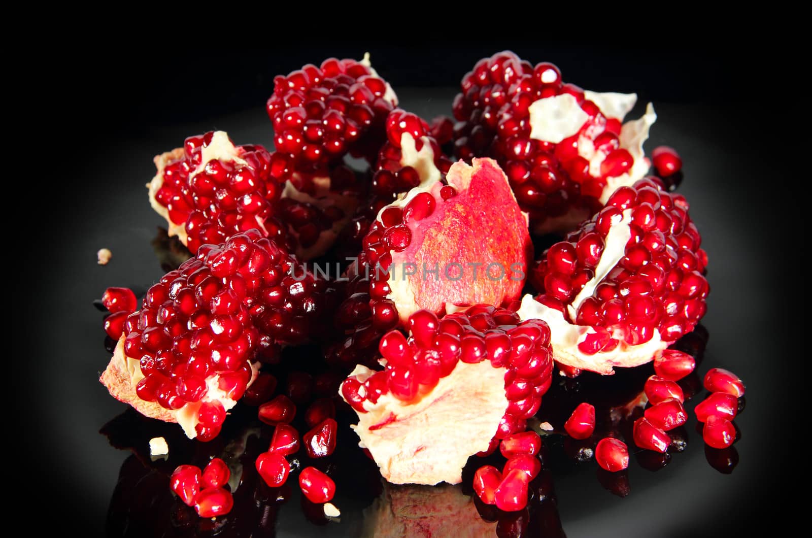 fresh ripe pomegranate pieces on black background