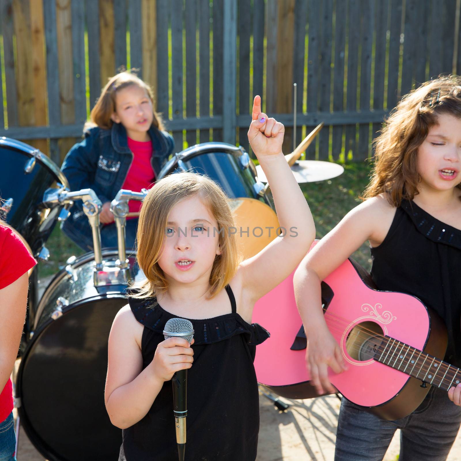 Blond kid singer girl singing playing live band in backyard concert with friends