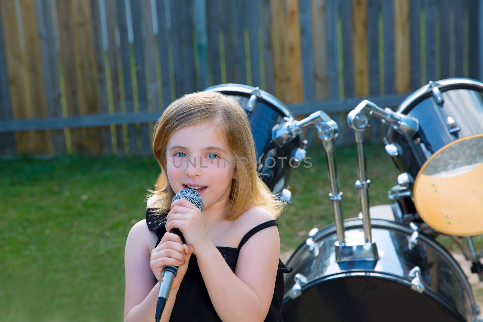 Blond kid girl singing in tha backyard with drums by lunamarina