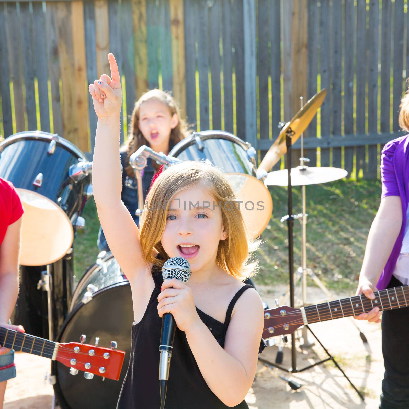 Blond kid singer girl singing playing live band in backyard concert with friends