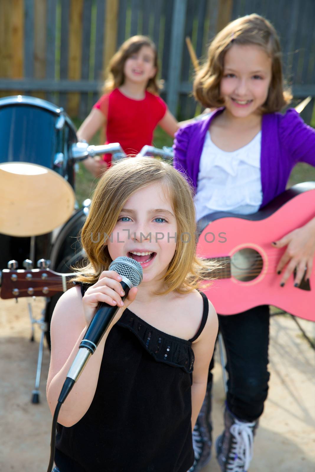 Blond kid singer girl singing playing live band in backyard concert with friends