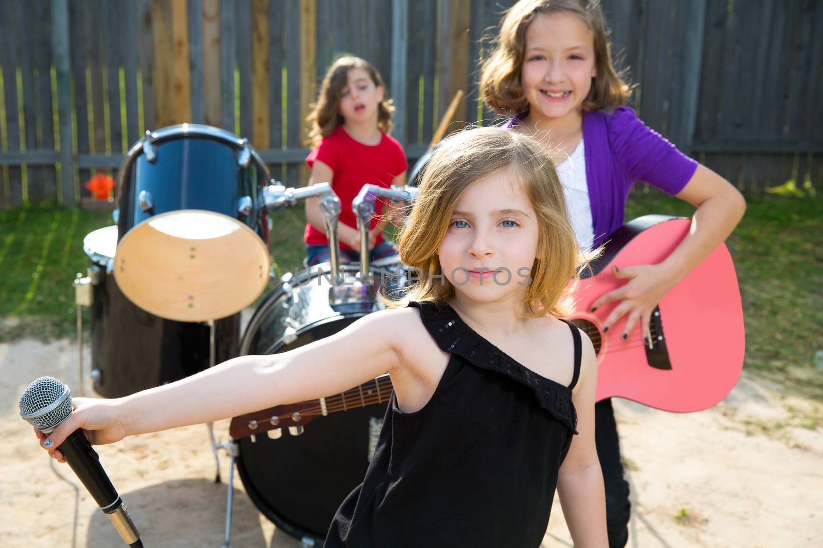 Blond kid singer girl singing playing live band in backyard concert with friends
