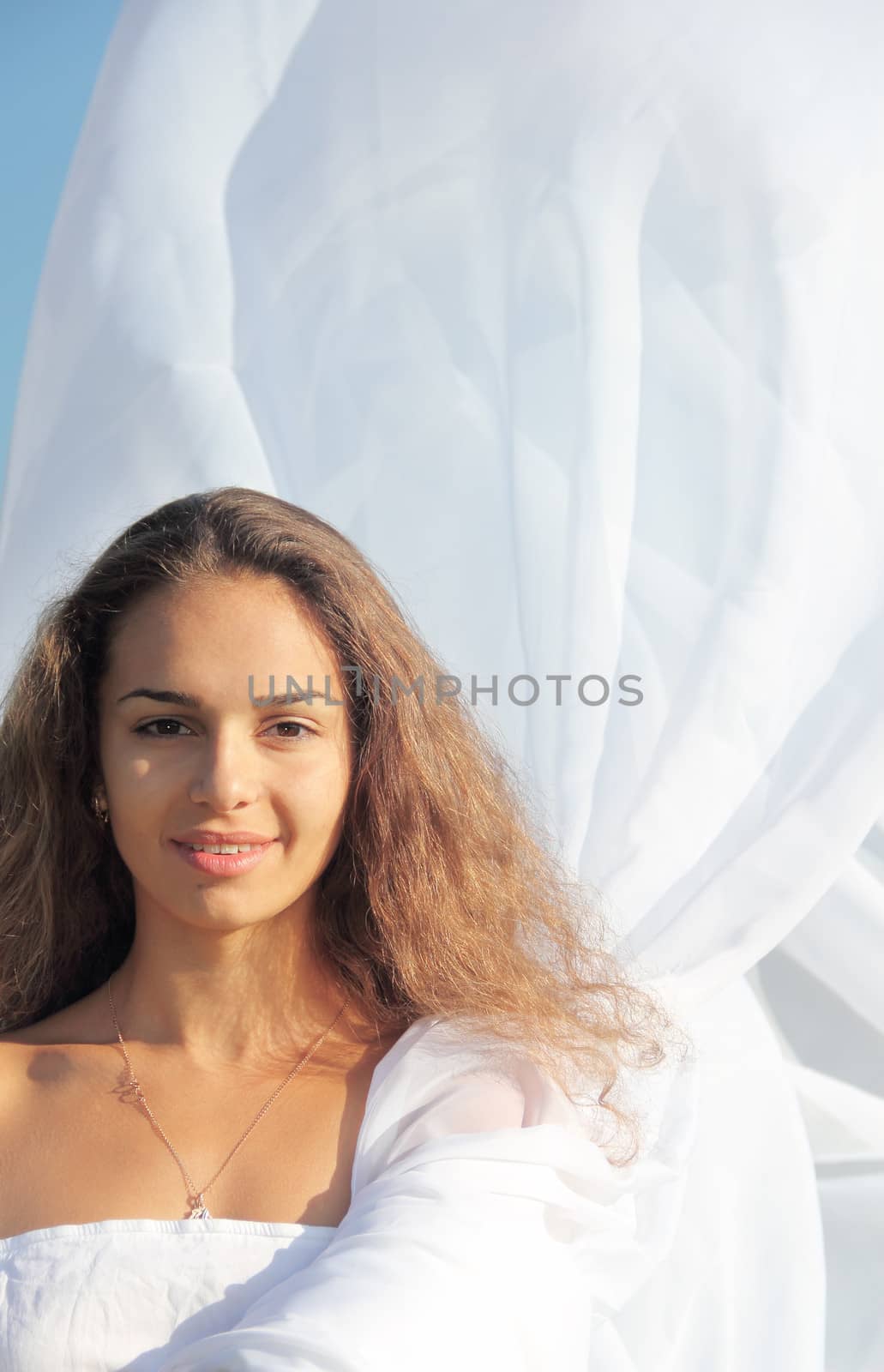 Portrait of a young woman wearing white dress outdoors