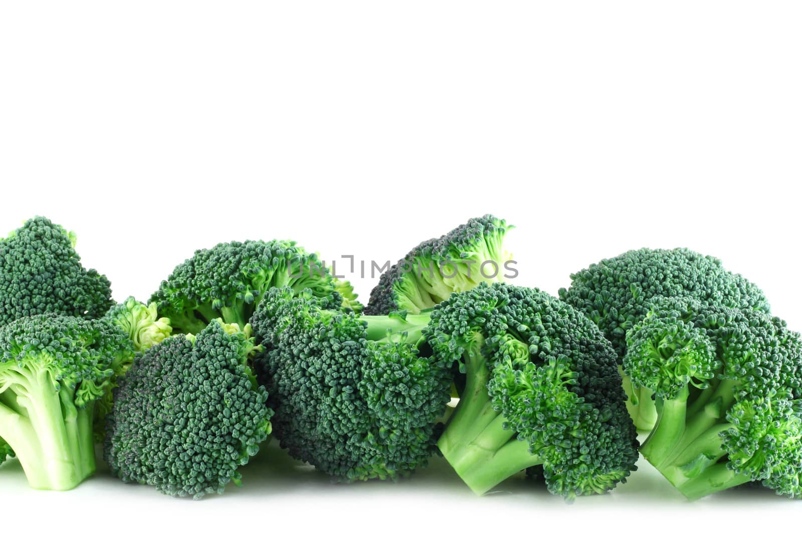 Fresh broccoli pieces in row isolated on white background