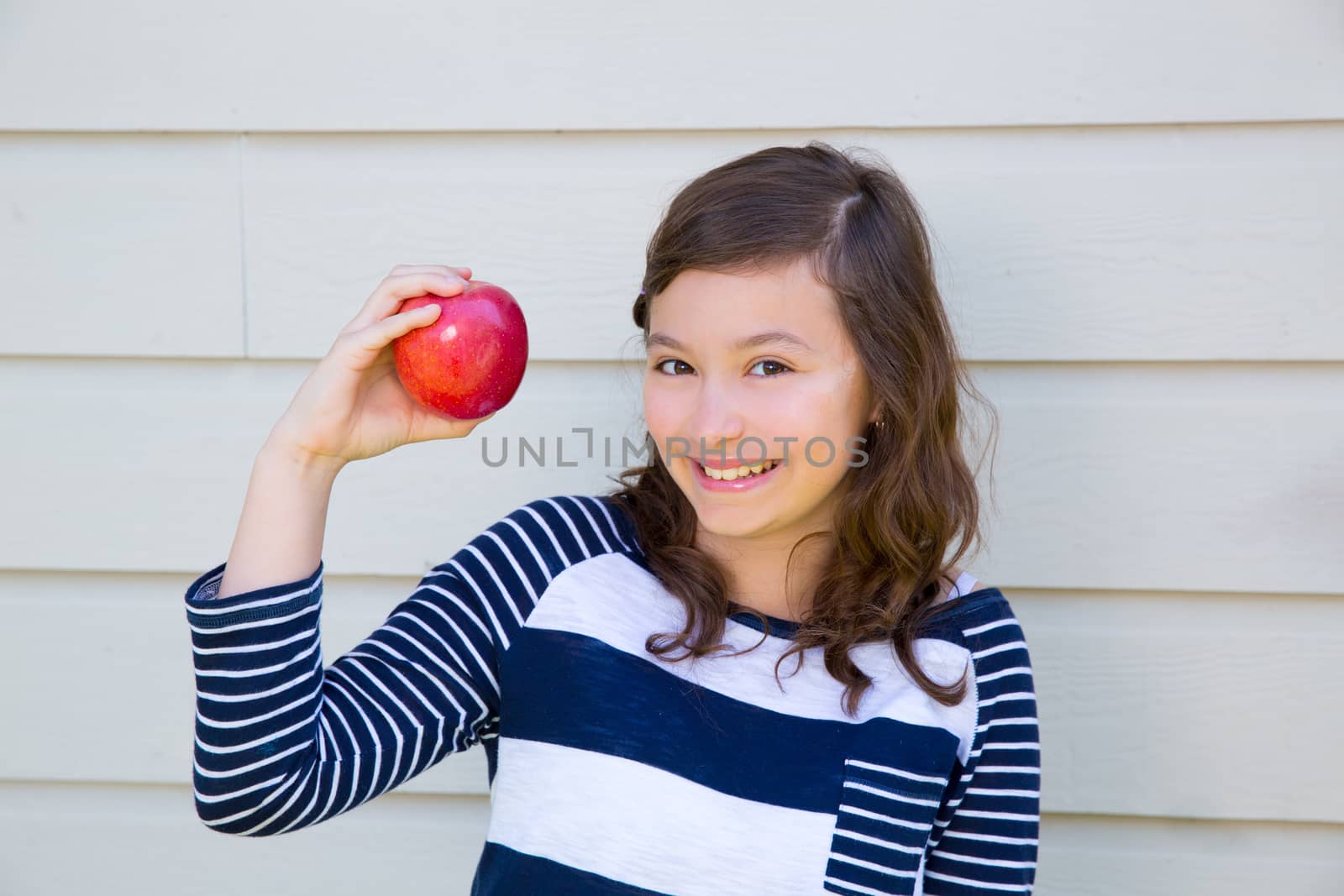 Teenager girl happy eating a red apple