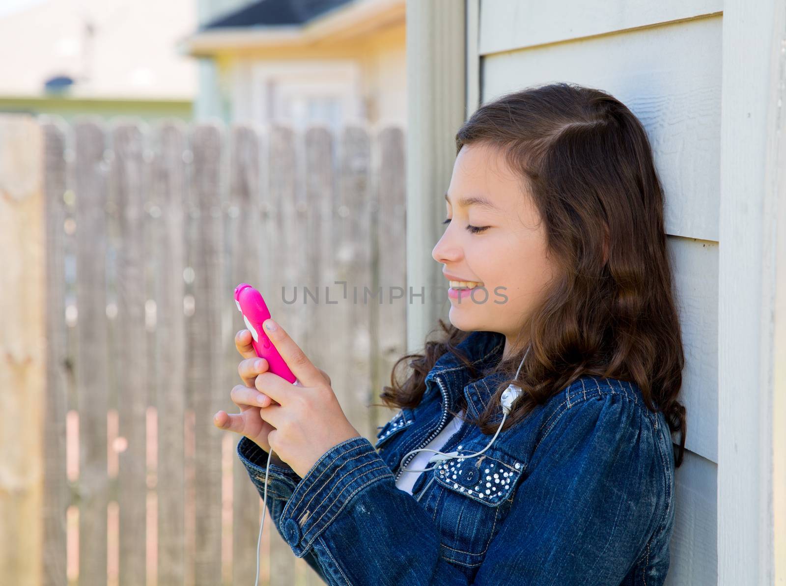 teen girl playing music with smartphone earings by lunamarina