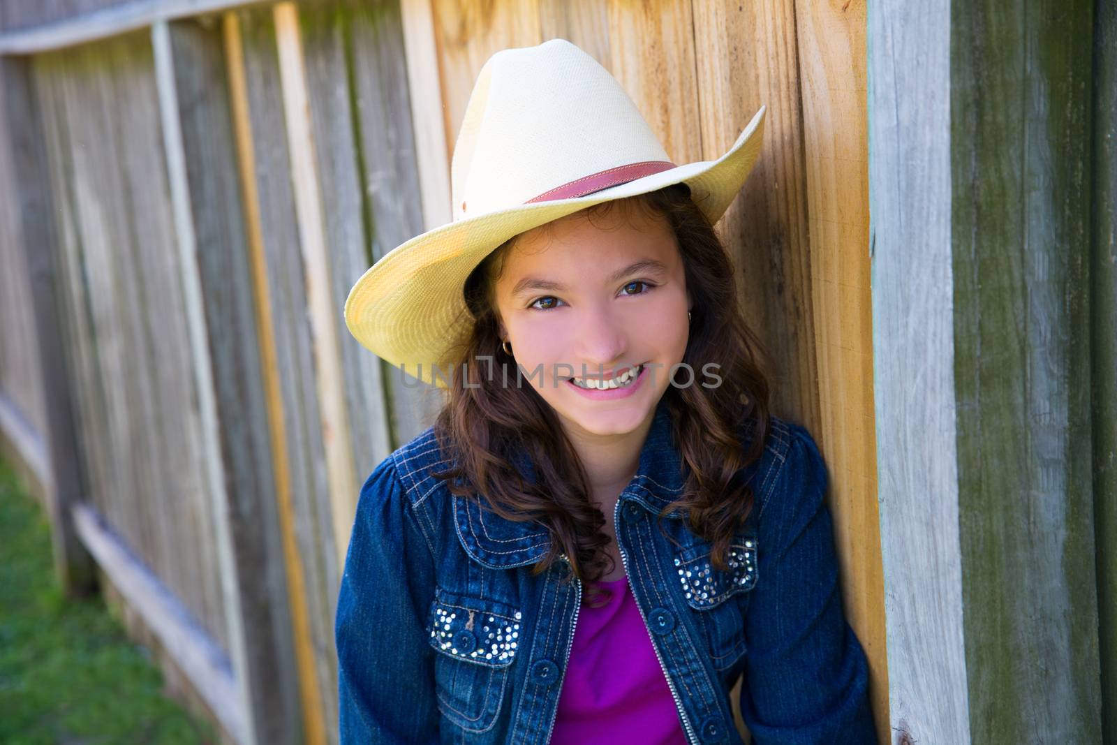 Little kid girl pretending to be a cowboy with father hat