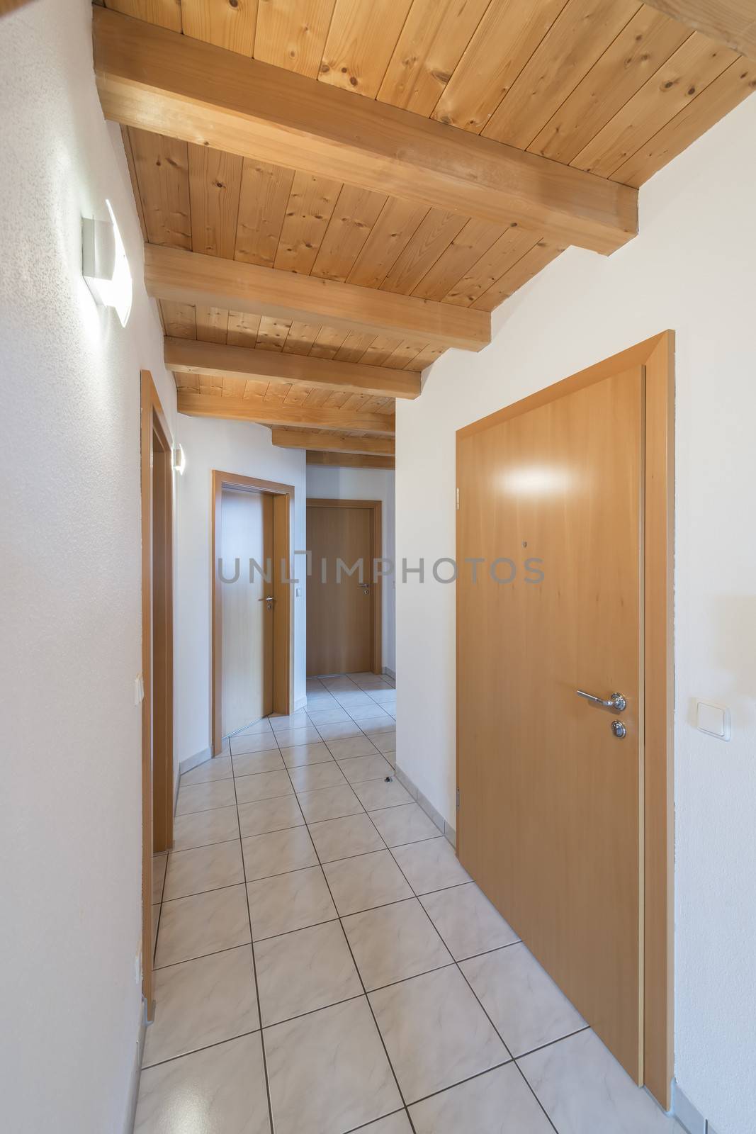 Corridor in an apartment with doors and white tiles