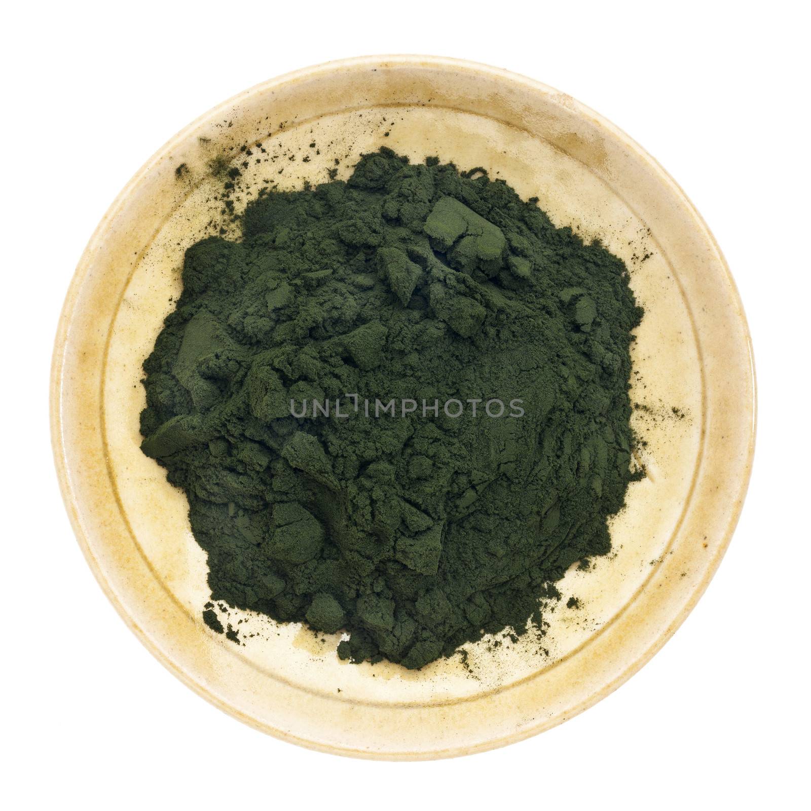Nutrient-rich organic chlorella powder on a small ceramic bowl, isolated on white, top view