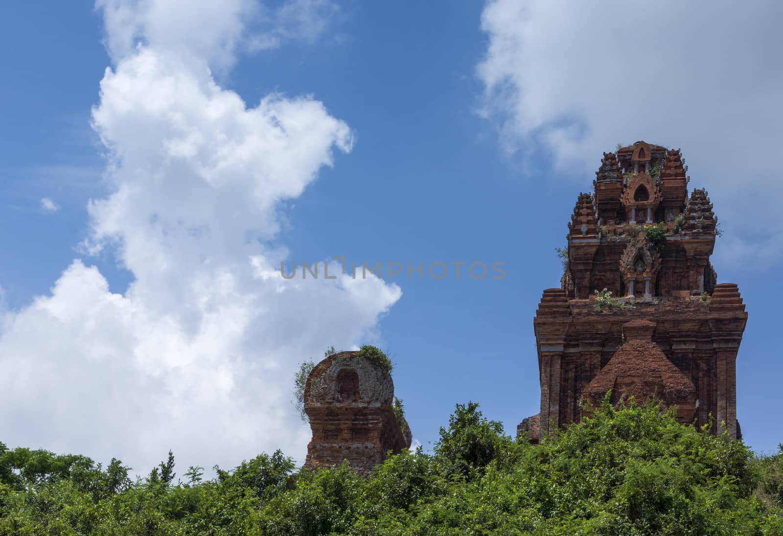 Banh It Cham towers against blue skies and white clouds. by Claudine