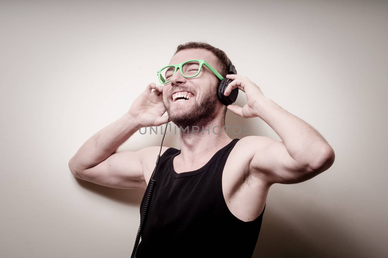 hipster stylish fashion blonde man with headphones on gray background
