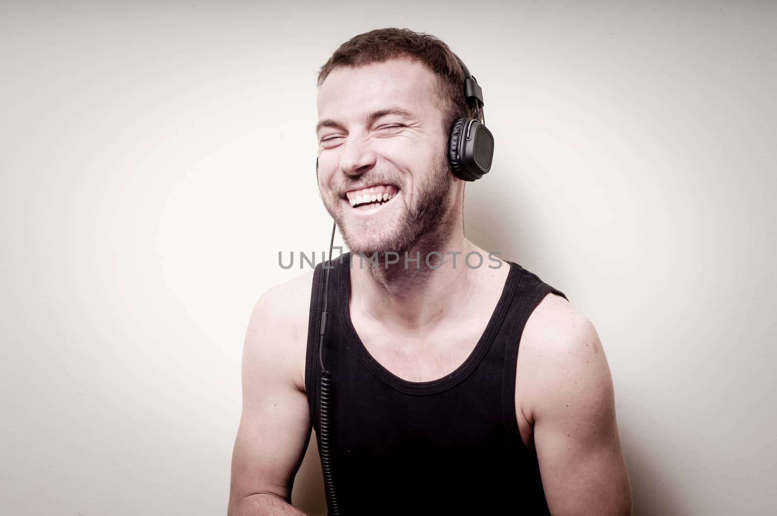 hipster stylish fashion blonde man with headphones on gray background