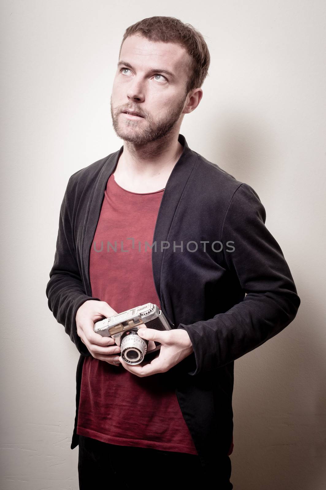 hipster stylish fashion man with old camera on gray background