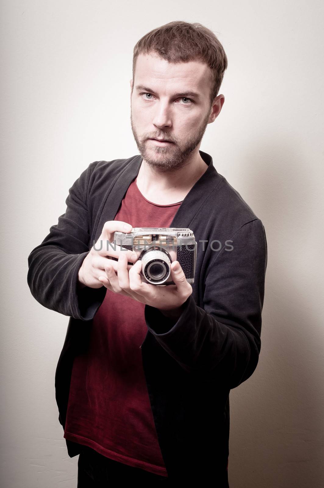 hipster stylish fashion man with old camera on gray background
