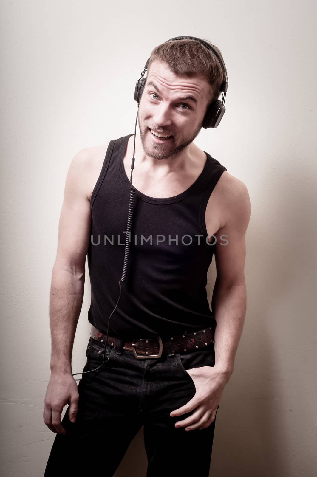hipster stylish fashion blonde man with headphones on gray background