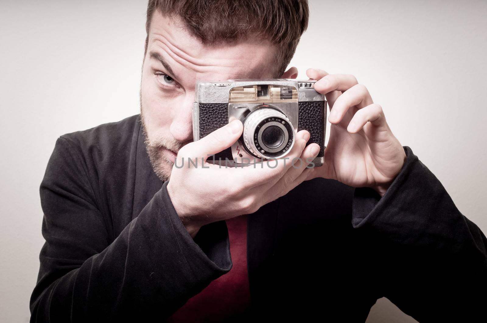hipster stylish fashion man with old camera on gray background
