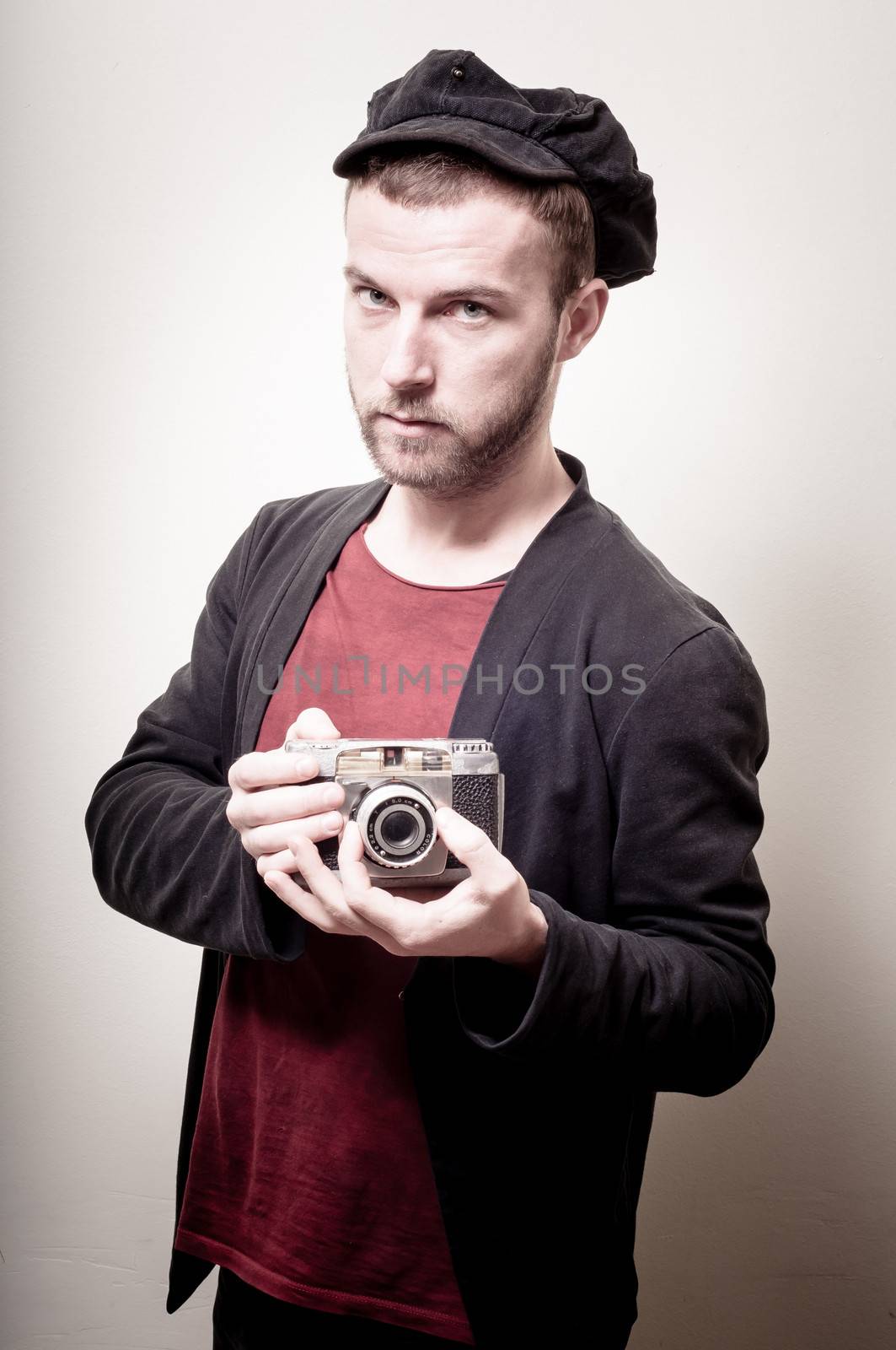 hipster stylish fashion man with old camera on gray background