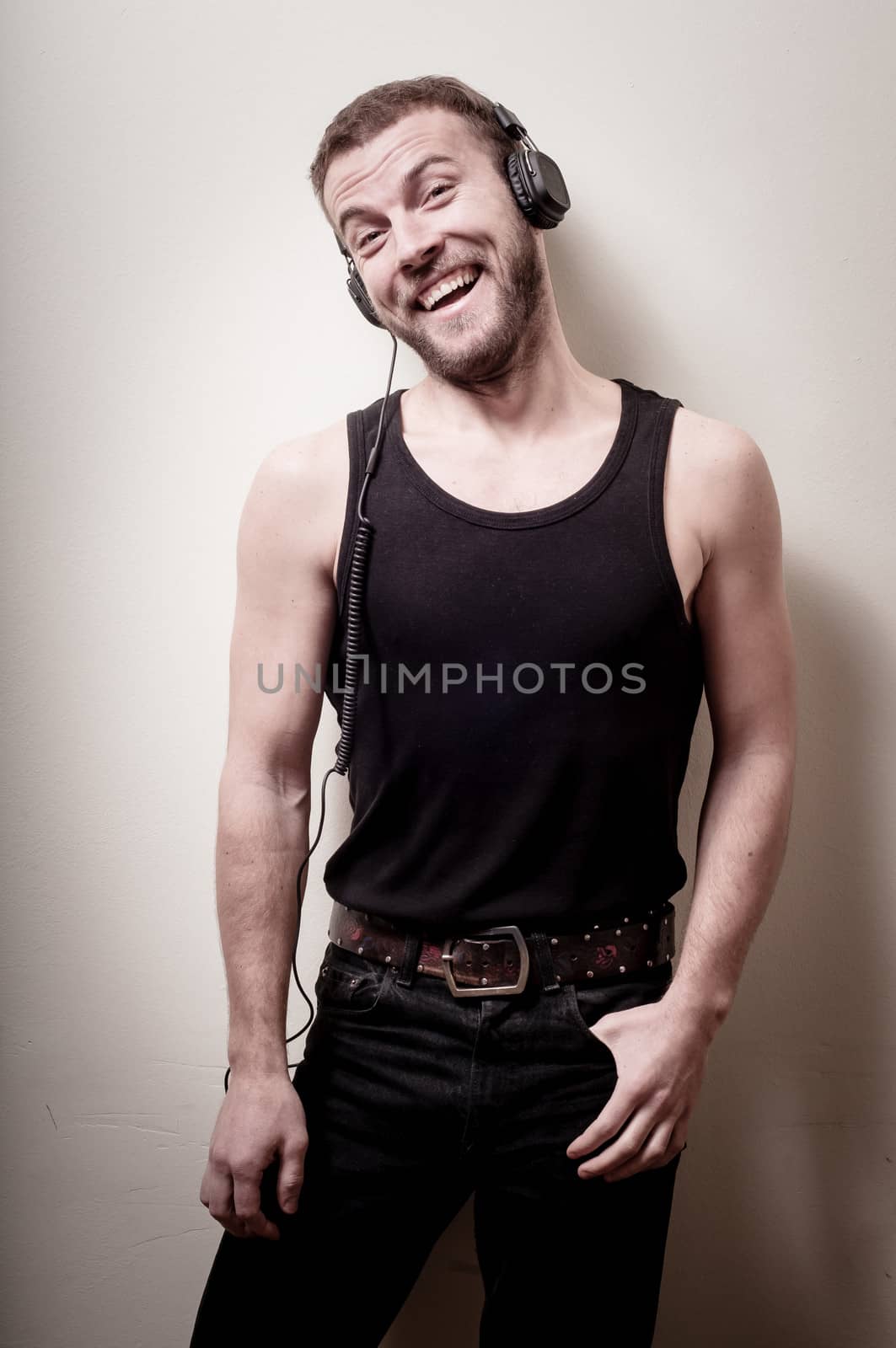 hipster stylish fashion blonde man with headphones on gray background