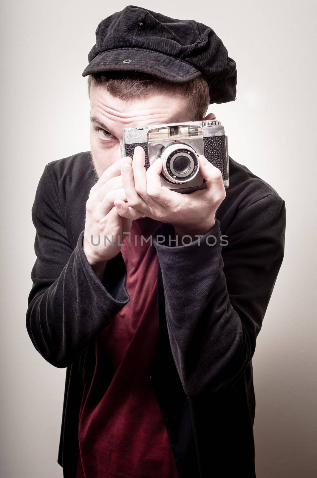 hipster stylish fashion man with old camera on gray background