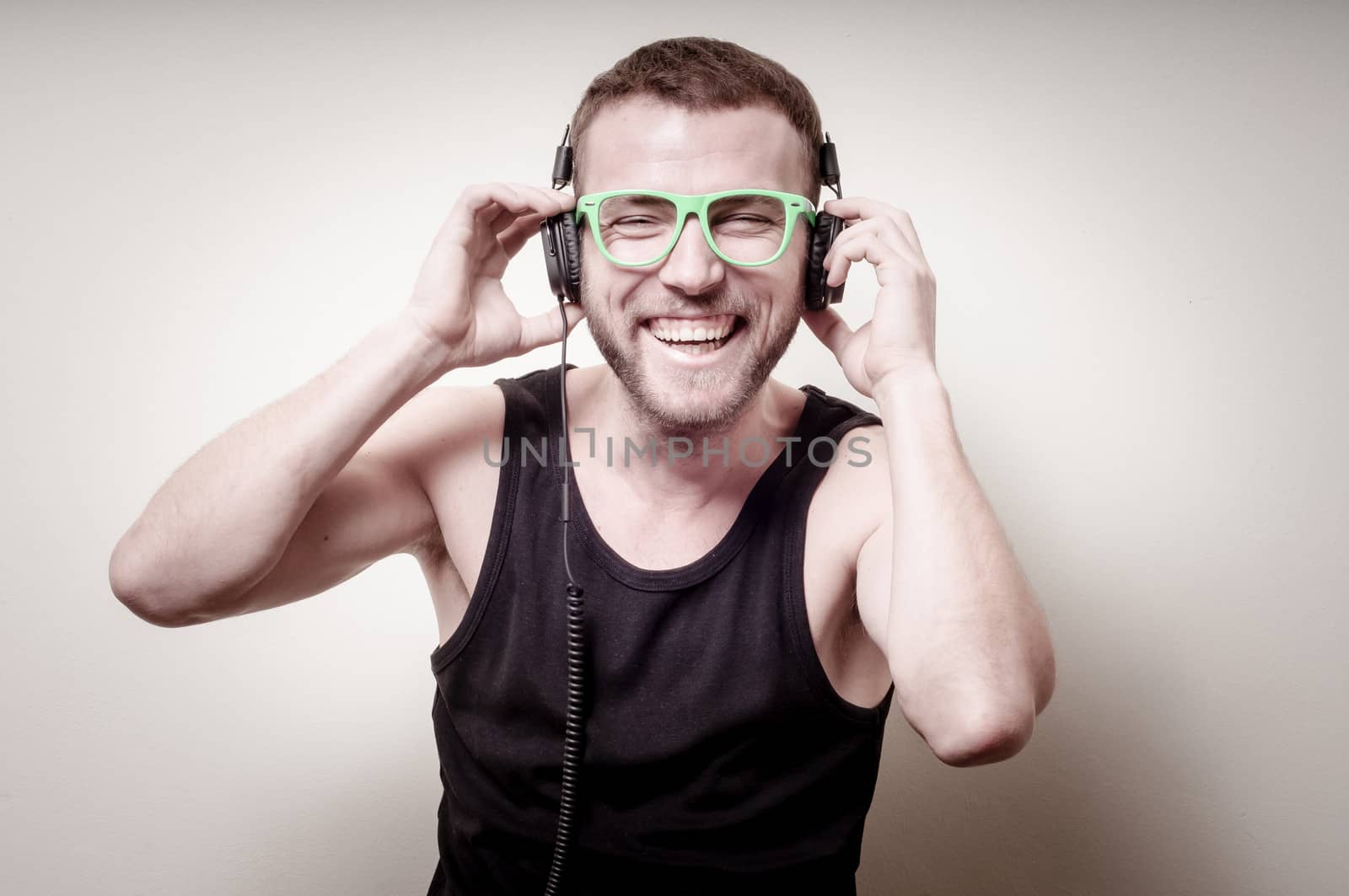 hipster stylish fashion blonde man with headphones on gray background