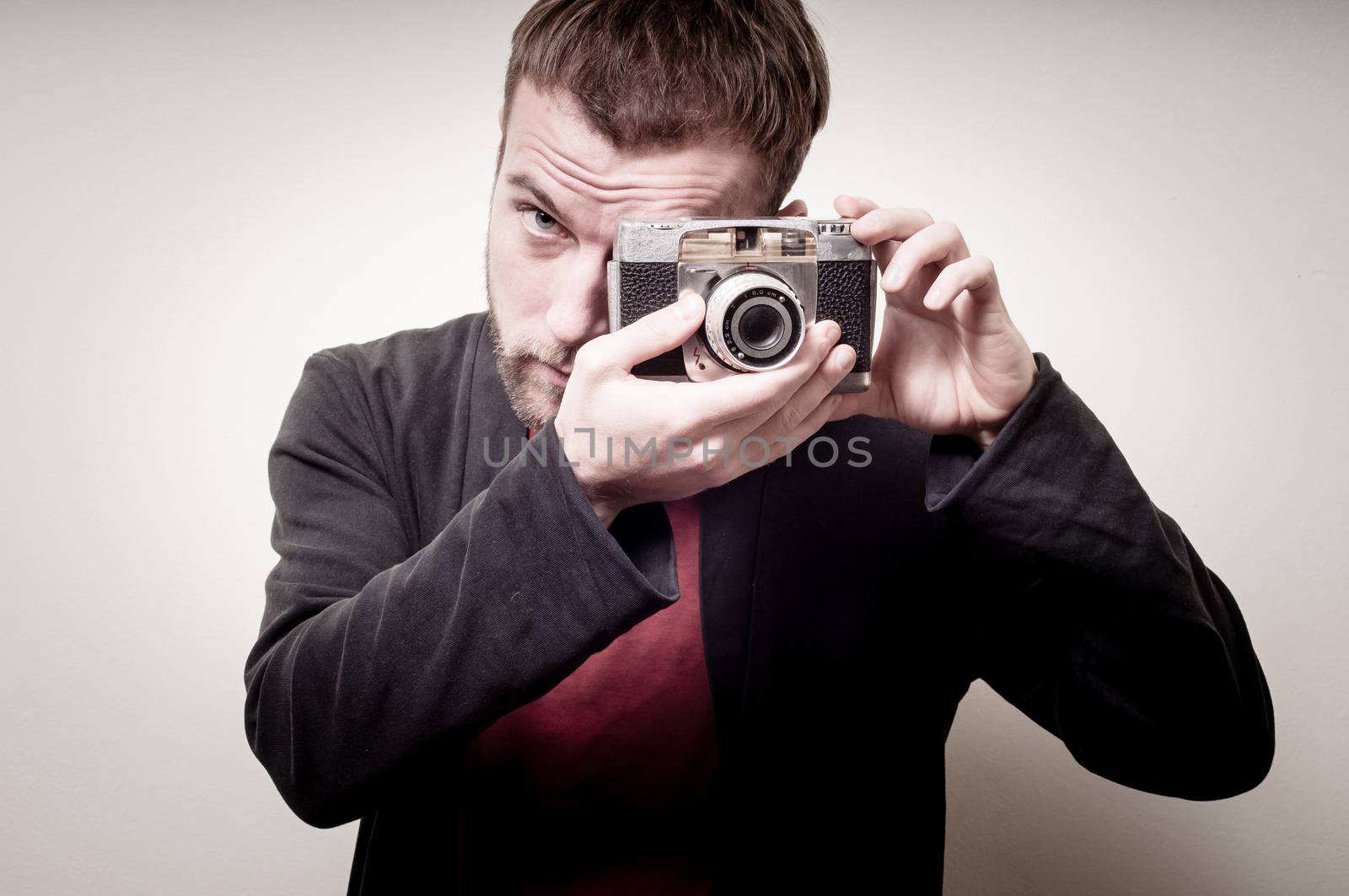 hipster stylish fashion man with old camera on gray background