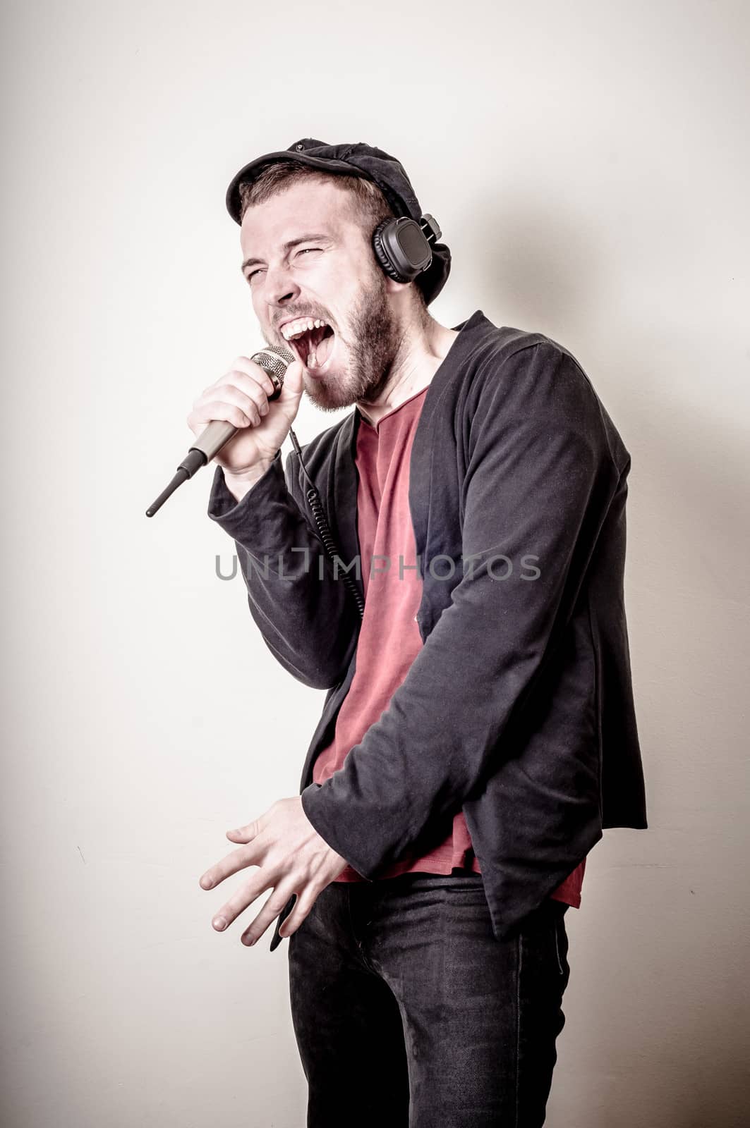 hipster stylish fashion blonde man with headphones on gray background